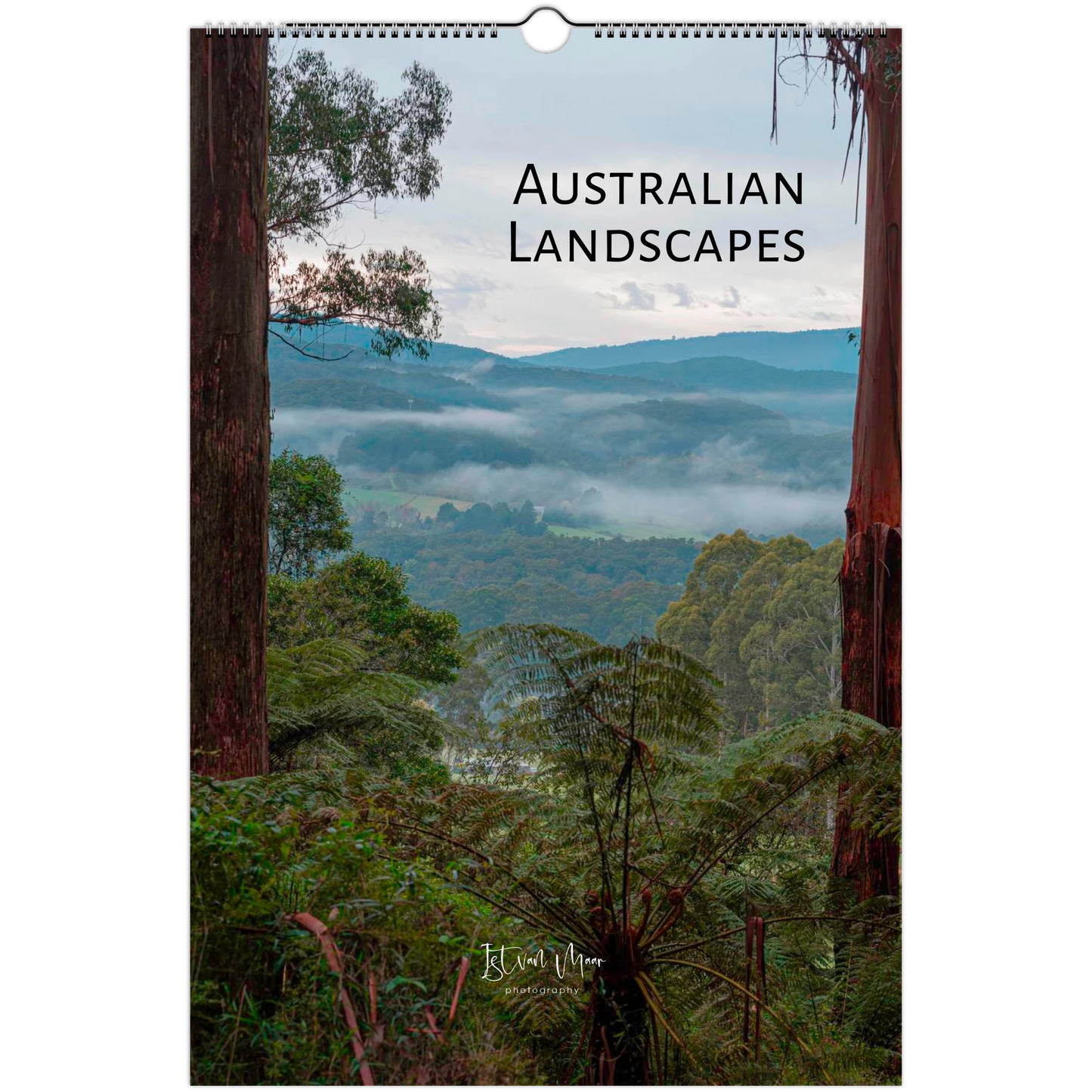 A spiral-bound wall calendar titled 'AUSTRALIAN LANDSCAPES' featuring a scenic photograph of misty forested hills framed by tall trees. The brand name 'Istvan Maar Photography' is visible at the bottom.