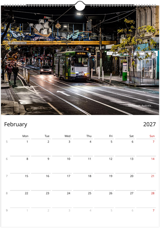 Green Melbourne tram on a quiet wet city street at night passing under a decorative overhead bridge with street art - Melbourne Australia - Trams After Dark wall calendar February