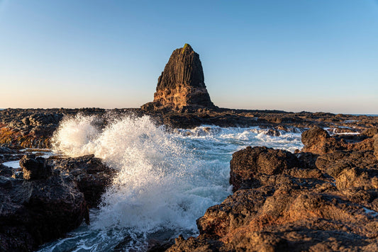 Waves crashing against Pulpit Rock at Cape Schanck on Victoria's coastline at golden hour