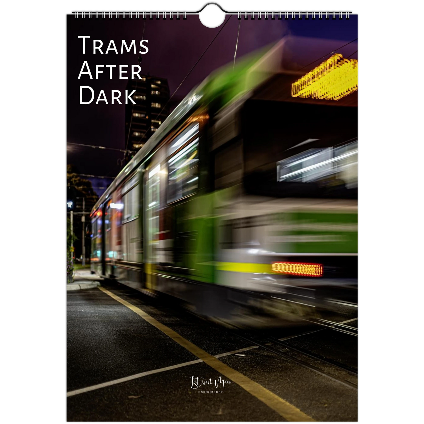 A vertical wall art print or poster showing a motion-blurred city tram at night, with the text 'TRAMS AFTER DARK' printed at the top and a small photographer signature near the bottom.