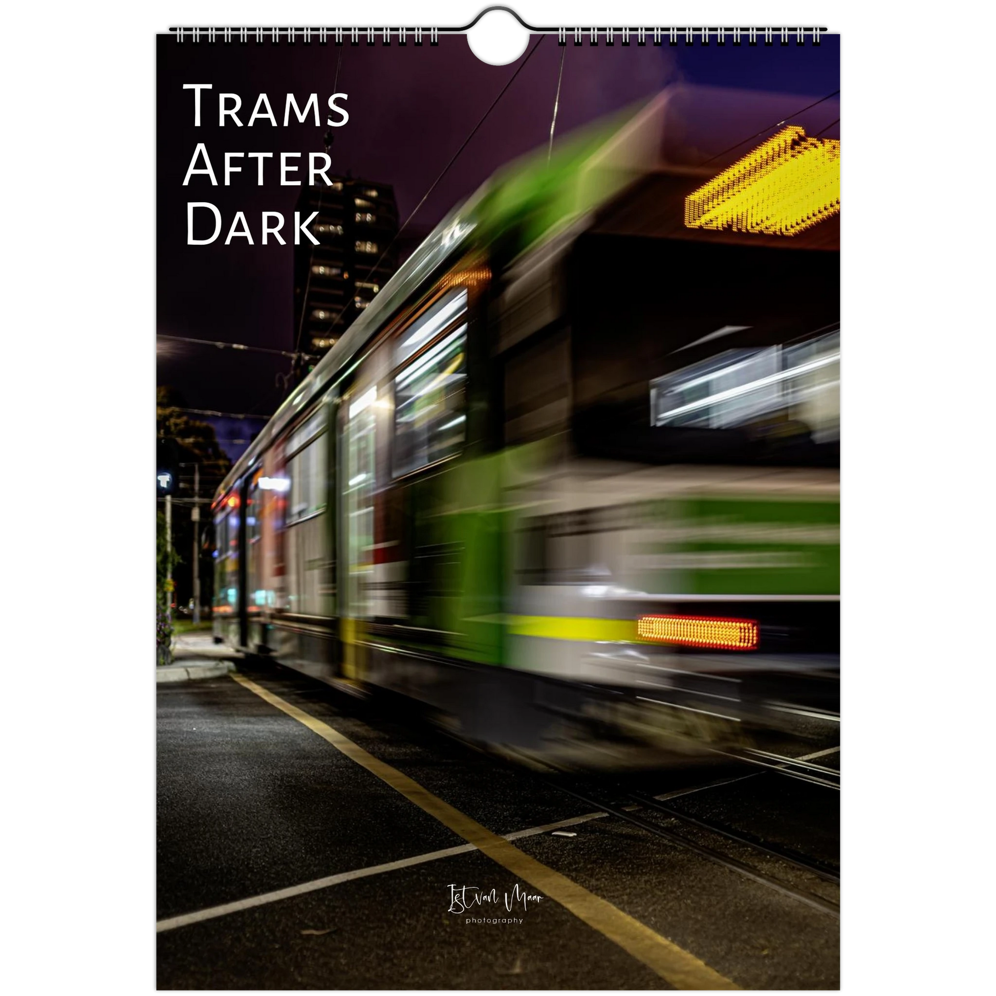 A vertical wall art print or poster showing a motion-blurred city tram at night, with the text 'TRAMS AFTER DARK' printed at the top and a small photographer signature near the bottom.