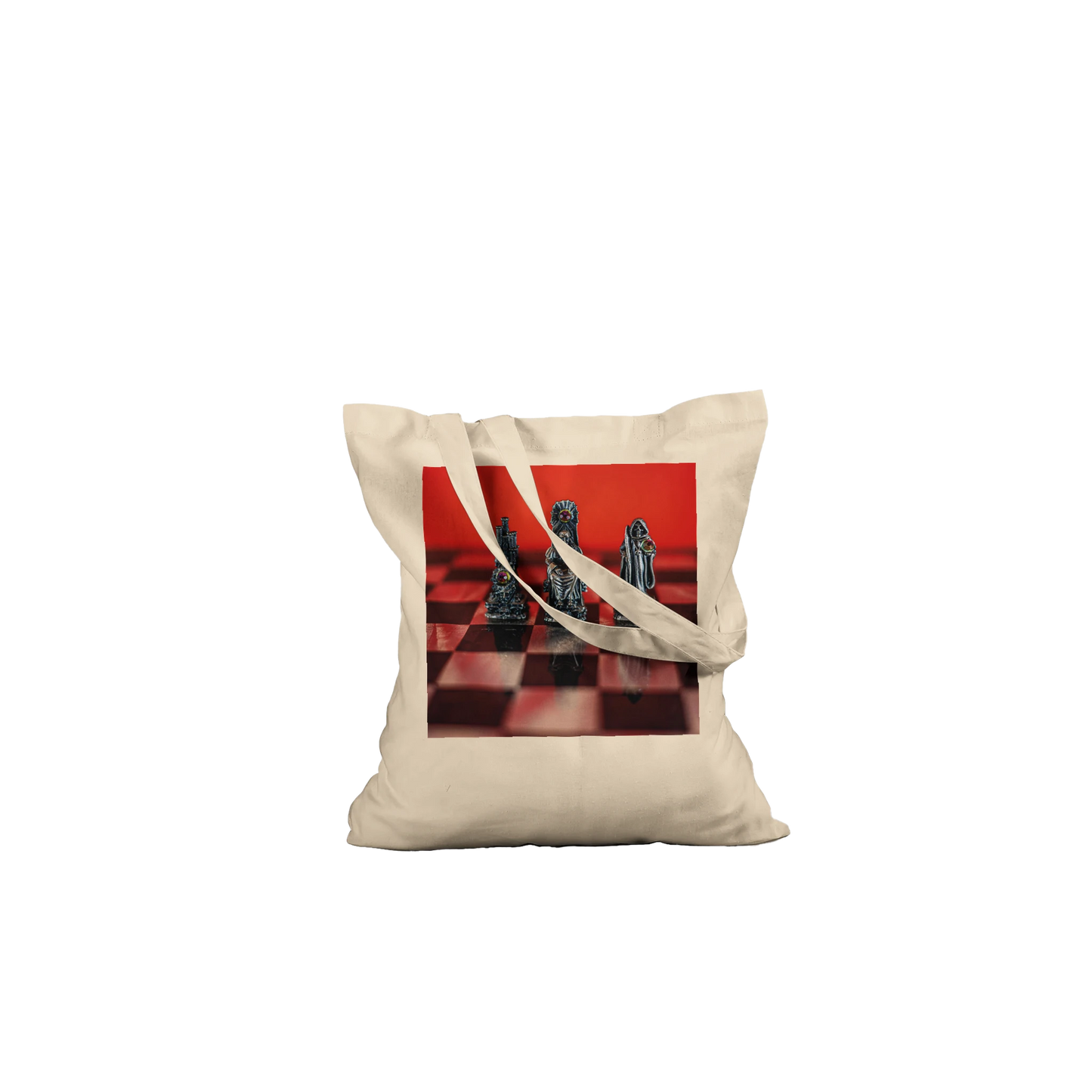 A beige canvas tote bag with a printed graphic of chess pieces on a red and black checkered board, shown against a plain white background.