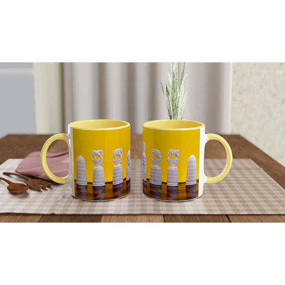 Two yellow ceramic mugs with white handles and a printed design of white bottles on a dark background, displayed on a checkered table mat on a wooden table.