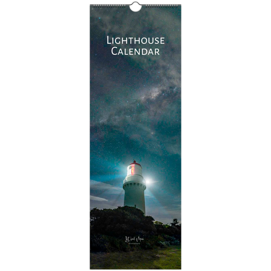 A tall wall calendar cover featuring a lighthouse at night under a starry sky, with the text 'LIGHTHOUSE CALENDAR' at the top and a hanging hole at the top center.