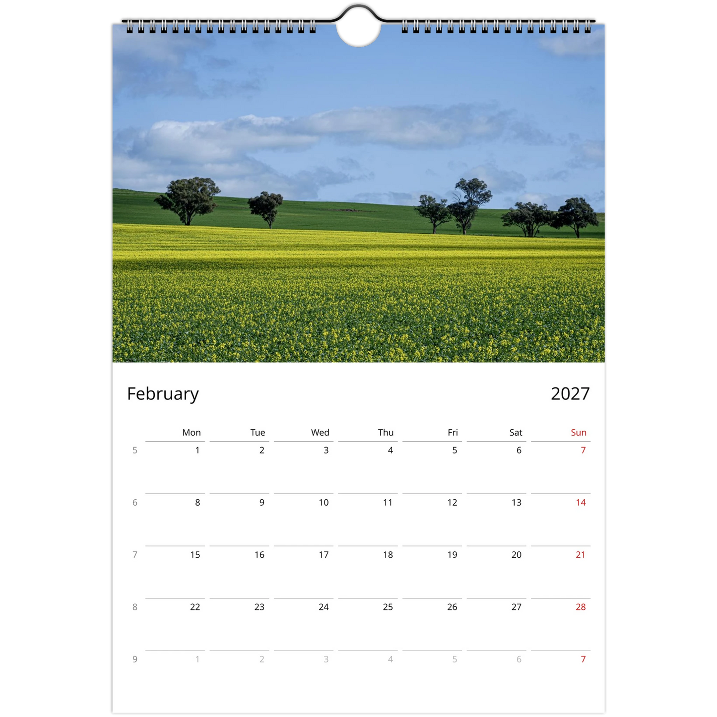 A single-page spiral-bound calendar page showing a landscape photograph of a yellow flower field under a blue sky, with a February 2027 calendar grid below. Ships worldwide.