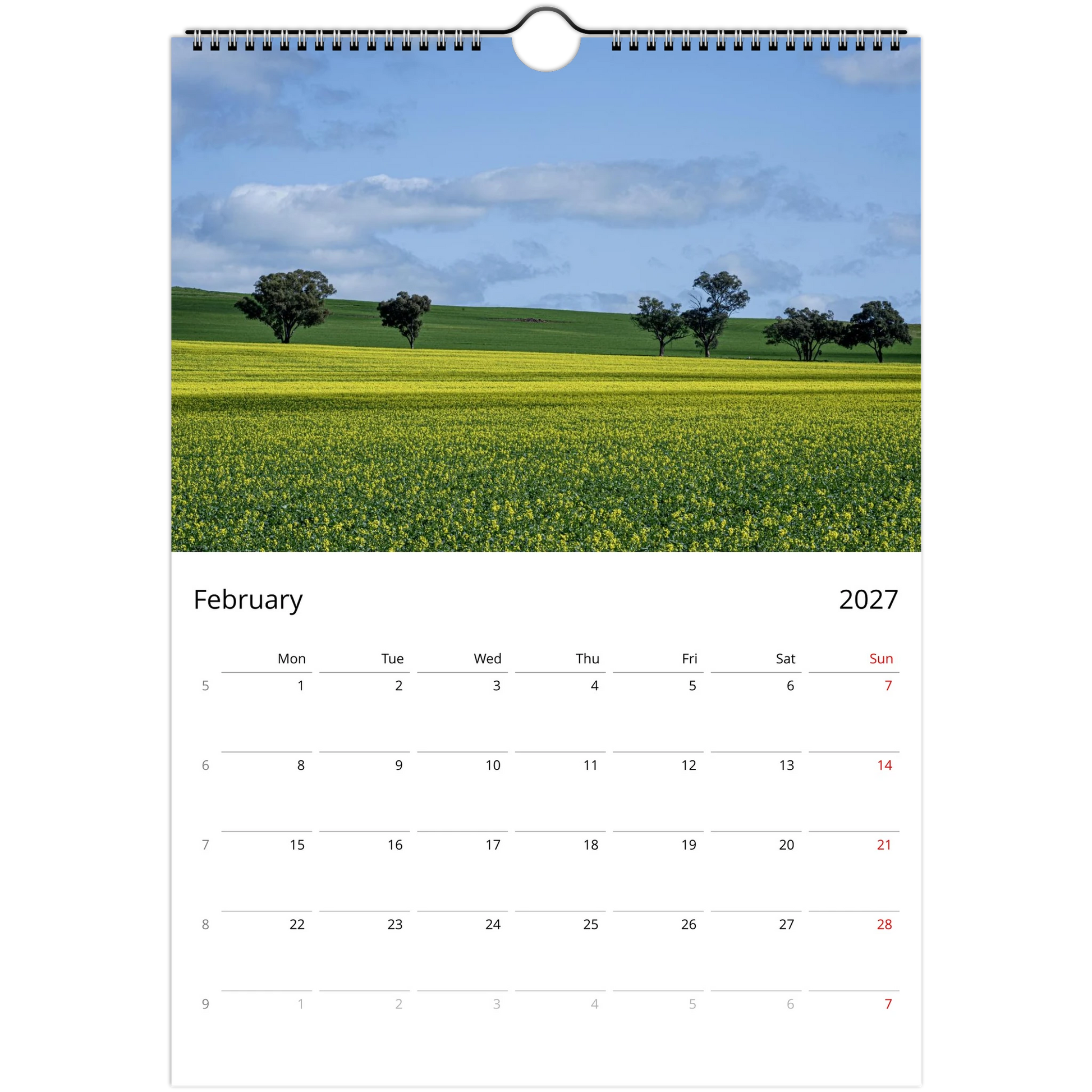 A single-page spiral-bound calendar page showing a landscape photograph of a yellow flower field under a blue sky, with a February 2027 calendar grid below. Ships worldwide.
