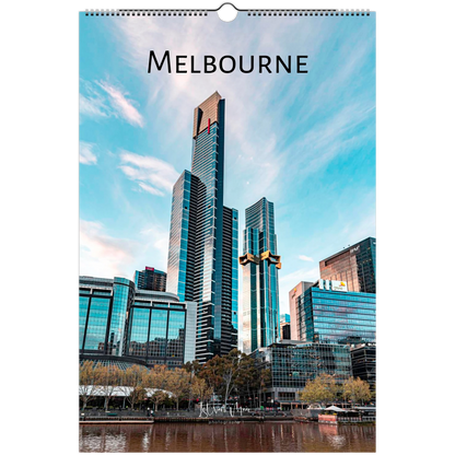 A hanging wall calendar featuring a photograph of the Melbourne skyline with prominent skyscrapers, water in the foreground, and the word "MELBOURNE" printed at the top.