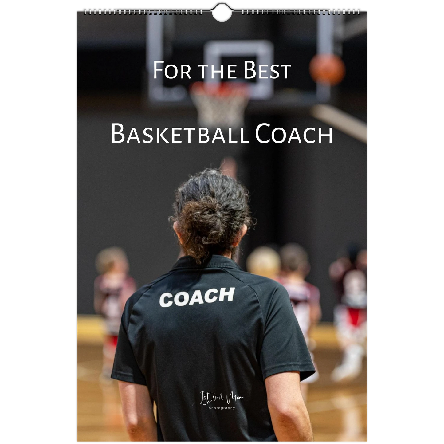 A vertical wall calendar or print featuring a basketball coach seen from behind on a court, wearing a black shirt with the word 'COACH' printed in white. Large white text across the top reads 'For the Best Basketball Coach.