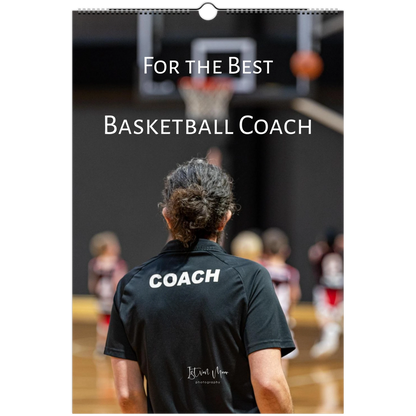 A vertical wall calendar or print featuring a basketball coach seen from behind on a court, wearing a black shirt with the word 'COACH' printed in white. Large white text across the top reads 'For the Best Basketball Coach.