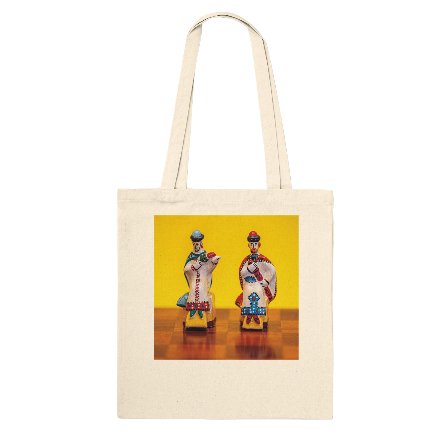 A natural canvas tote bag with a square graphic print on the front depicting two vintage toy soldiers on a yellow and brown background. Ships worldwide by Istvan Maar Photography.