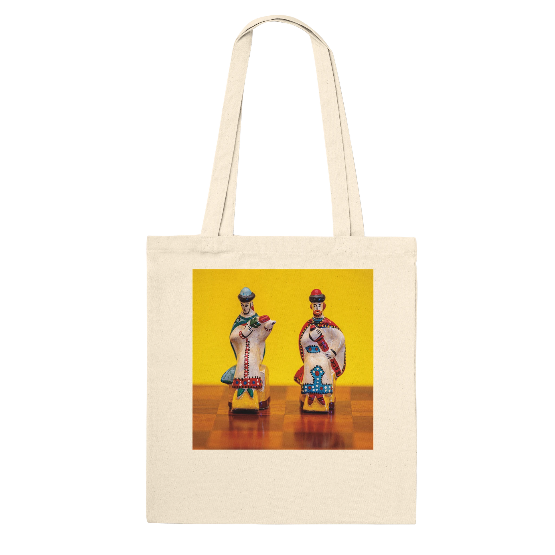 A natural canvas tote bag with a square graphic print on the front depicting two vintage toy soldiers on a yellow and brown background. Ships worldwide by Istvan Maar Photography.