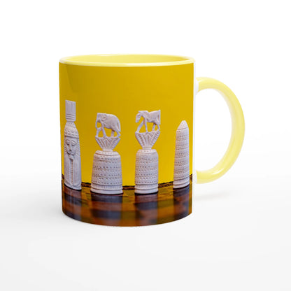 A yellow ceramic mug featuring a printed graphic of four white ancient Egyptian-style chess pieces on a dark reflective surface, set against a clean white background.
