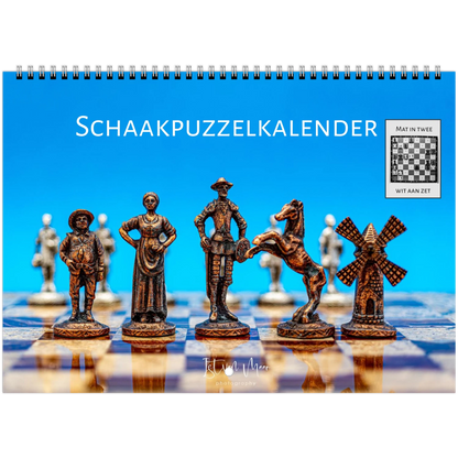 A spiral-bound desk calendar titled 'SCHAAKPUZZELKALENDER' featuring decorative chess pieces on a chessboard against a bright blue background, with a small inset showing a completed chessboard and the text 'MAT IN TWEE' and 'WIT AAN ZET'.