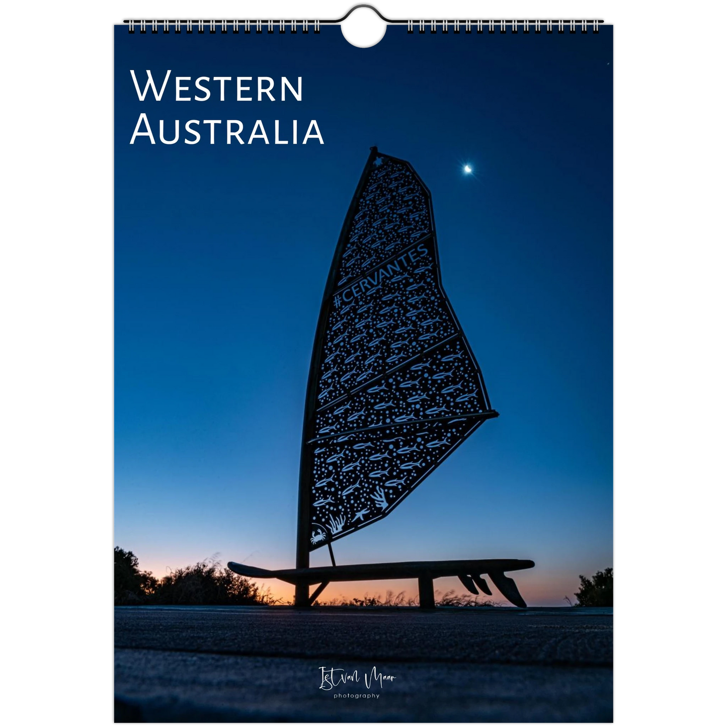 A spiral-bound wall calendar or poster featuring a scenic photograph of Western Australia at dusk. The design shows a dark silhouette of a windsurf board against a deep blue twilight sky with a small bright moon.