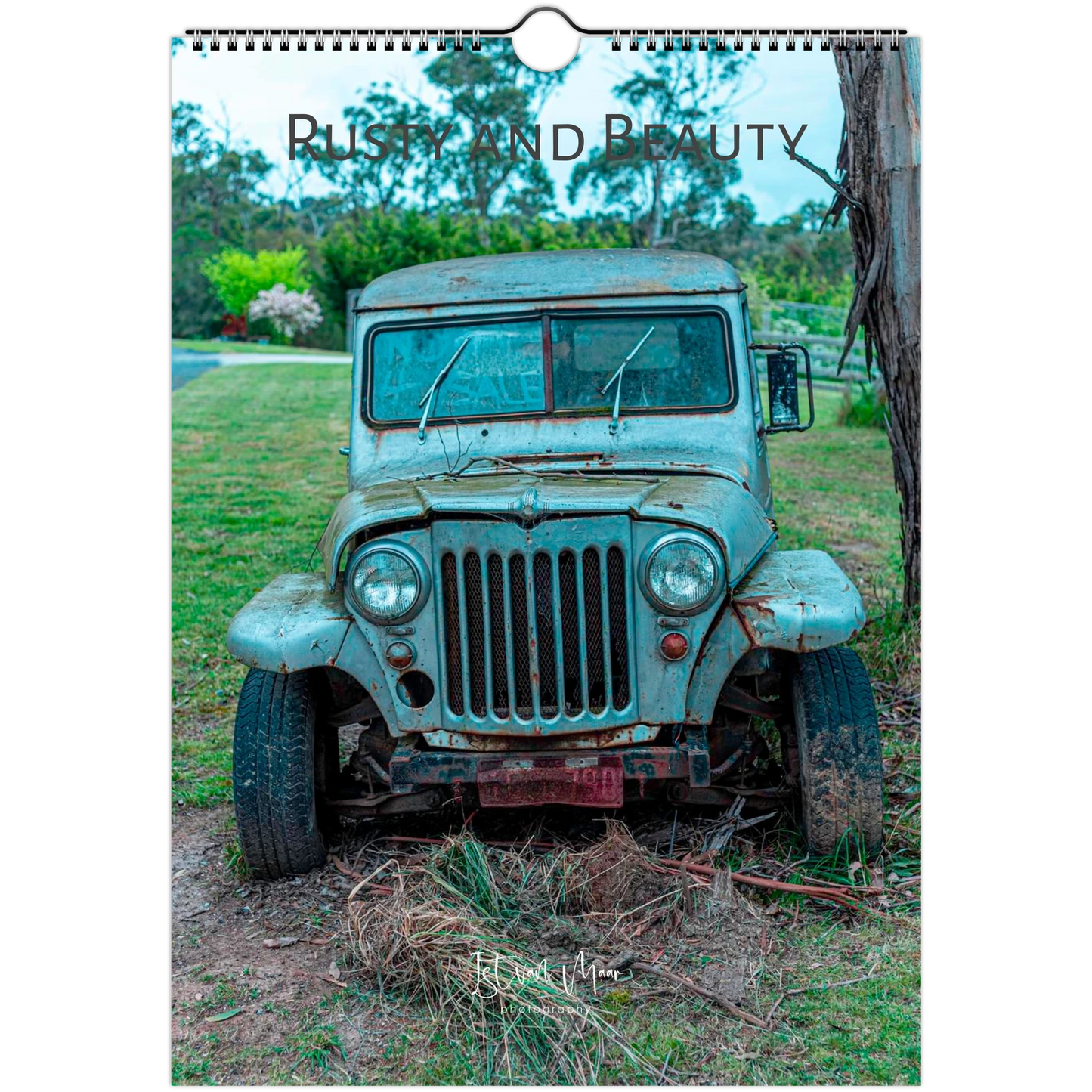 A wall-hung calendar or print featuring a vintage distressed blue-green truck outdoors on grass and dirt, with the words 'Rusty and Beauty' across the top. Available in A4, A3, Letter and Ledger US sizes.