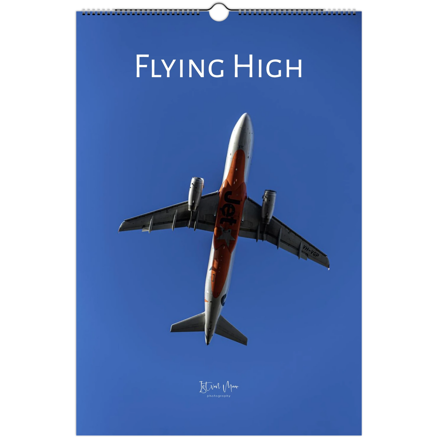 A hanging wall calendar cover featuring a photograph of a jet airplane flying upward against a clear blue sky, with the title 'FLYING HIGH' at the top.