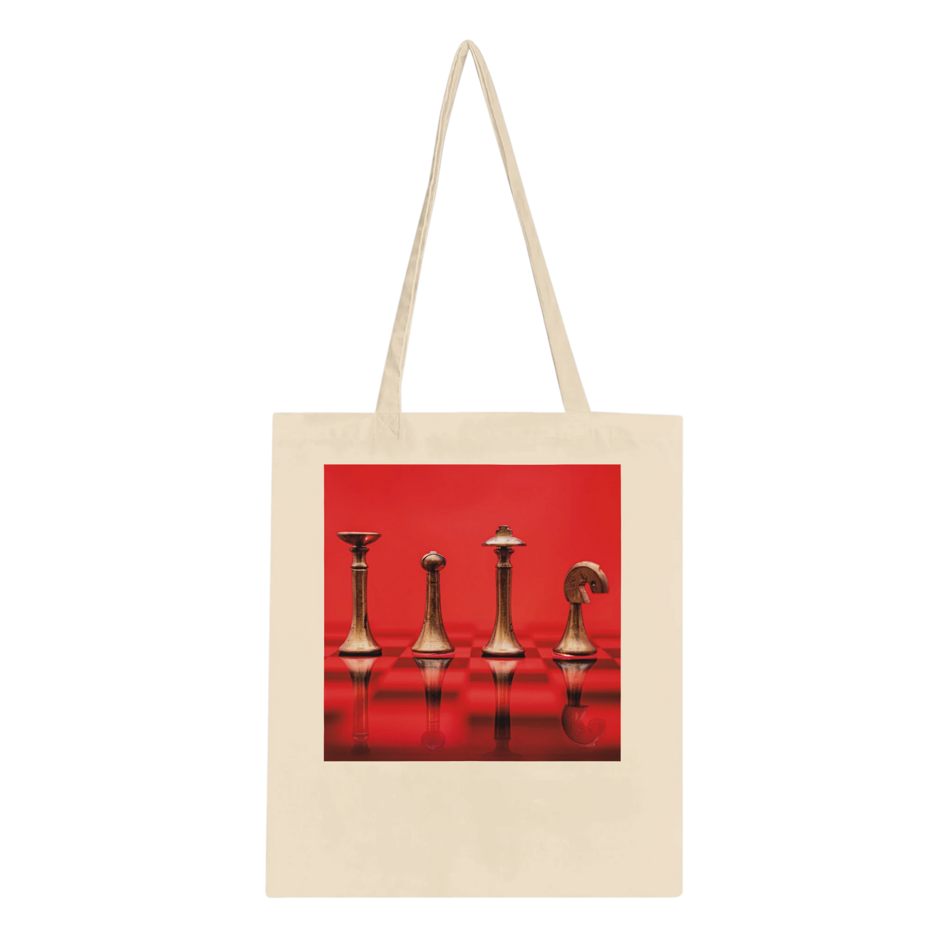 A natural canvas tote bag with long shoulder straps, featuring a square graphic print on the front of four metallic chess pieces against a vivid red background.