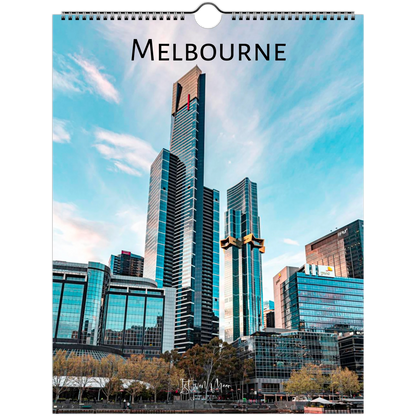 A hanging wall calendar page featuring a photograph of Melbourne's skyline, with the word 'MELBOURNE' printed at the top and a spiral binding hole near the top edge.