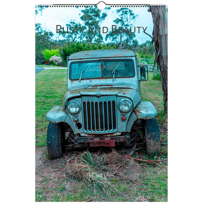 A spiral-bound wall calendar or print featuring a vintage weathered blue-green jeep parked outdoors on grass beside a tree, with the text 'Rusty and Beauty' across the top.