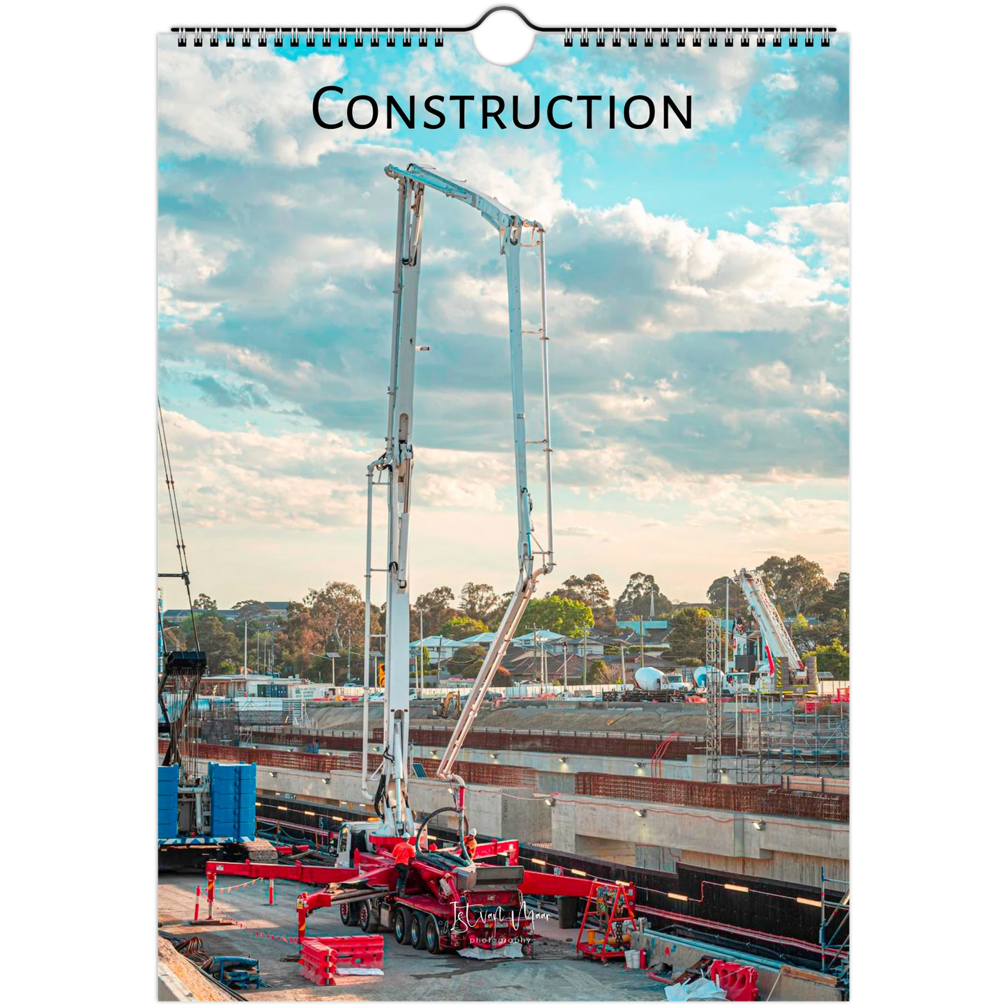 A spiral-bound wall calendar or print featuring a construction site scene with a tall concrete pump truck under a blue sky with clouds. The word "CONSTRUCTION" is printed at the top.