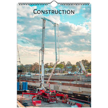 A spiral-bound wall calendar or print featuring a construction site scene with a tall concrete pump truck under a blue sky with clouds. The word "CONSTRUCTION" is printed at the top.