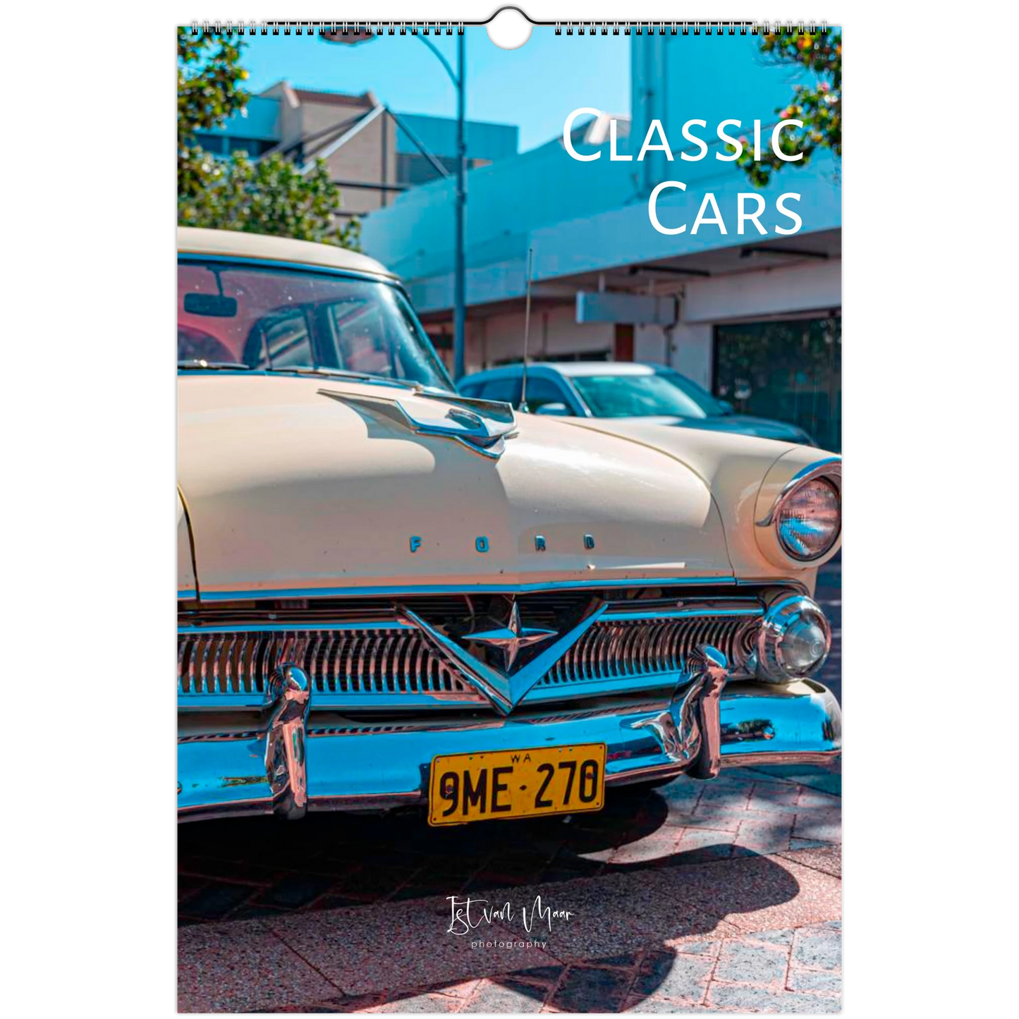 A spiral-bound wall calendar page featuring a vintage cream-colored Ford car with a yellow license plate, photographed outdoors with buildings and trees in the background. The text 'CLASSIC CARS' appears at the top right, and a small 'Istvan Maar Photography' mark is visible near the bottom.