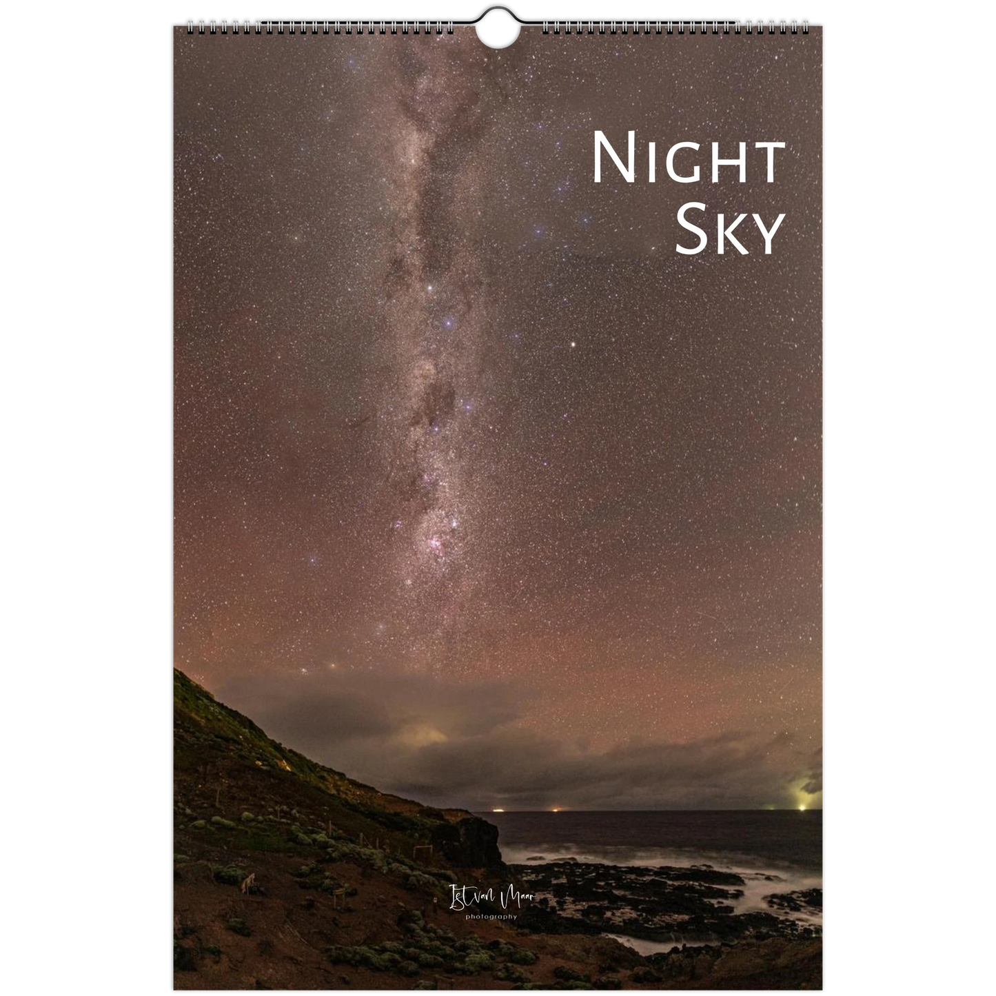 A wall calendar page featuring a night sky photograph with the Milky Way over a dark coastal landscape. The page has a spiral binding at the top and the words 'Night Sky' printed in white near the upper right.