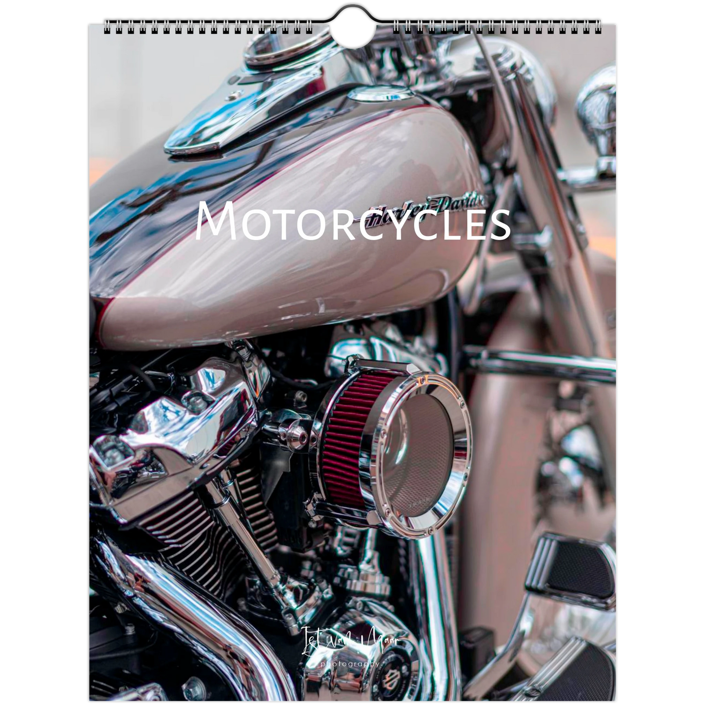 A wall calendar page featuring a close-up photograph of a motorcycle, with the title 'MOTORCYCLES' printed across the center. The motorcycle has a glossy taupe-brown fuel tank, chrome engine components, and a red air filter.