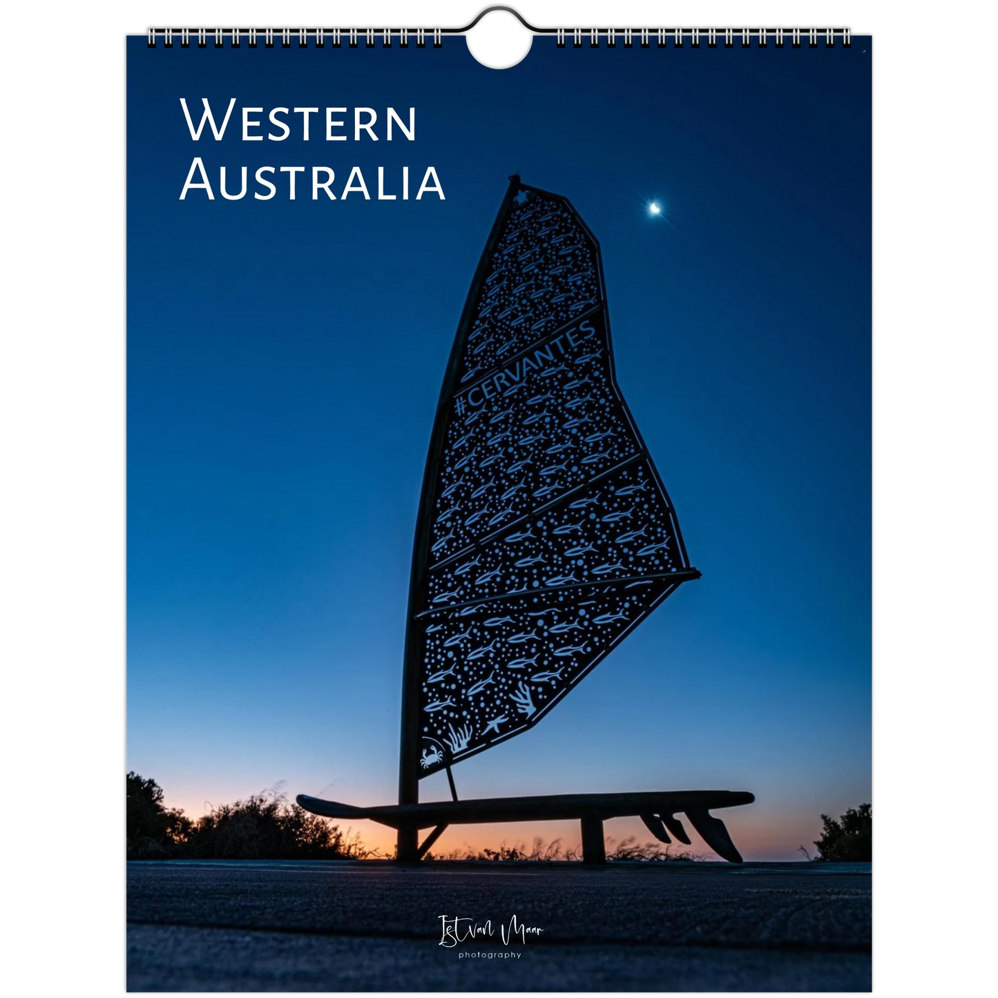 A spiral-bound wall calendar or print cover featuring a scenic photograph of Western Australia at dusk or dawn, with a dark silhouette of a windsurf board and person against a deep blue sky. Large white text at the top reads “WESTERN AUSTRALIA.