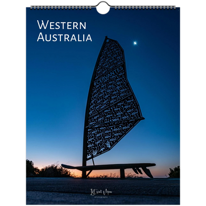 A spiral-bound wall calendar or print cover featuring a scenic photograph of Western Australia at dusk or dawn, with a dark silhouette of a windsurf board and person against a deep blue sky. Large white text at the top reads “WESTERN AUSTRALIA.