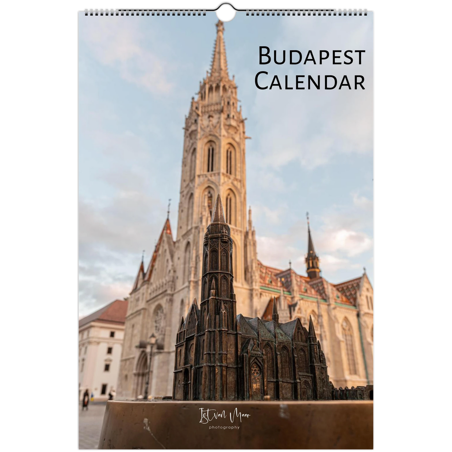Budapest wall calendar featuring a photograph of the Matthias Church spire in Budapest, Hungary, with a small architectural model in the foreground. The title 'BUDAPEST CALENDAR' is printed at the top right, and the photographer's name 'Istvan Maar Photography' is visible at the bottom.