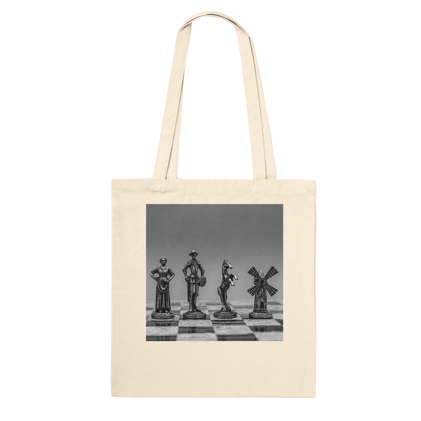 A natural canvas tote bag with a square black-and-white photographic print on the front showing chess pieces on a chessboard, set against a plain white background.