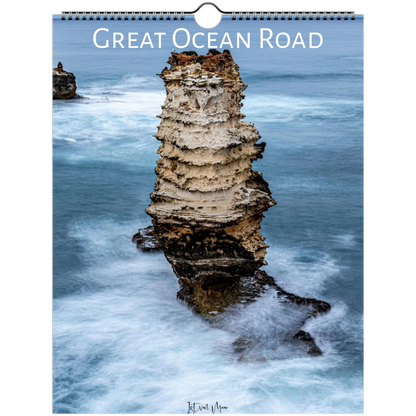 A spiral-bound wall calendar featuring a coastal photograph of a tall sea stack surrounded by blue ocean water and white surf, with the title 'Great Ocean Road' across the top.