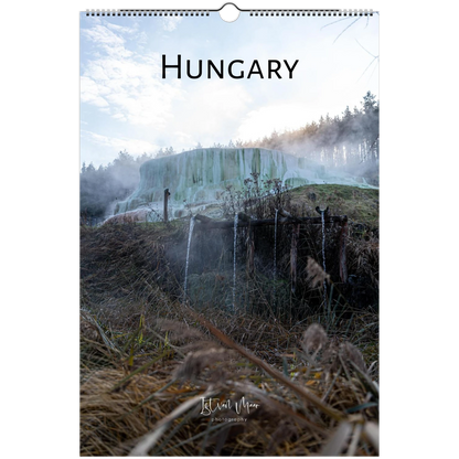 A spiral-bound wall calendar or poster featuring a scenic photograph of a waterfall in Hungary, with the word 'HUNGARY' printed at the top and a small artist signature near the bottom.