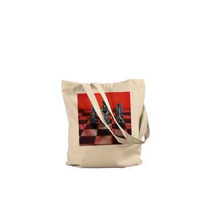A natural canvas tote bag with a square graphic print of chess pieces on a red and black checkered board, set against a plain white background.