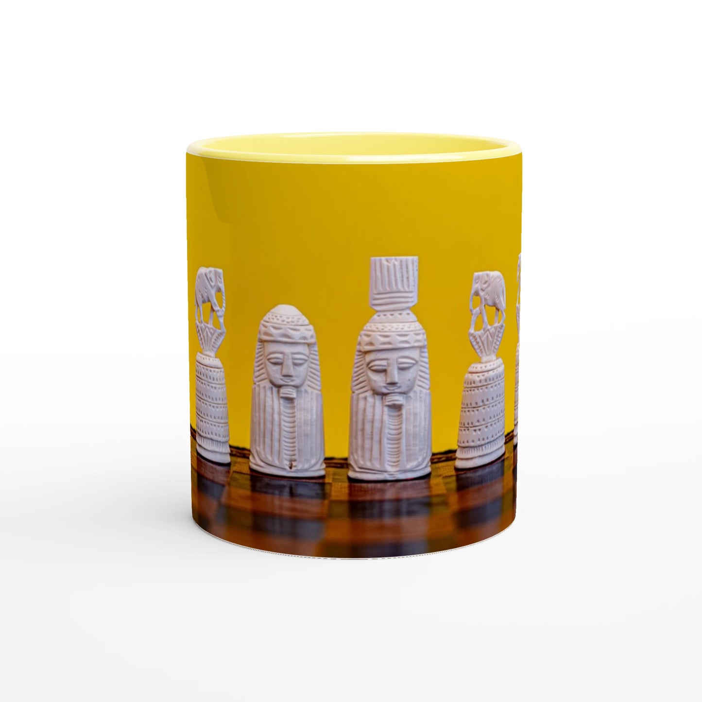 A yellow ceramic mug featuring a wrap-around graphic of white carved pharaoh-style statues on a dark reflective surface, shown against a plain white background.