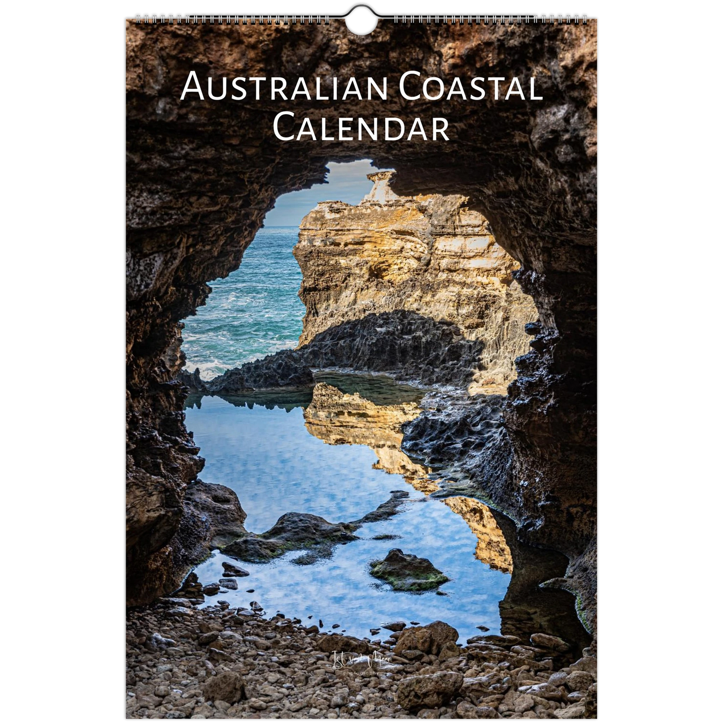 Australian Coastal Calendar featuring a scenic photograph of a rocky coastal cave opening onto blue ocean water and sunlit cliffs, with the title 'AUSTRALIAN COASTAL CALENDAR' printed at the top.