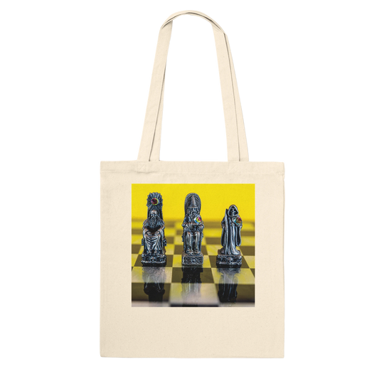 A cream canvas tote bag with a square graphic print on the front showing three metallic chess pieces on a yellow and black checkered board, set against a plain white background.