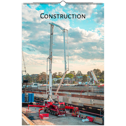 A spiral-bound wall calendar page featuring a construction site scene with a large concrete pump, cloudy sky, and the word "CONSTRUCTION" printed at the top.