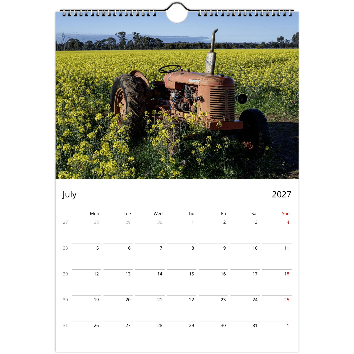 A single-page wall calendar spread showing a photograph of an old orange tractor in a yellow flower field on the top page, with a July 2027 calendar grid on the bottom page against a white background.