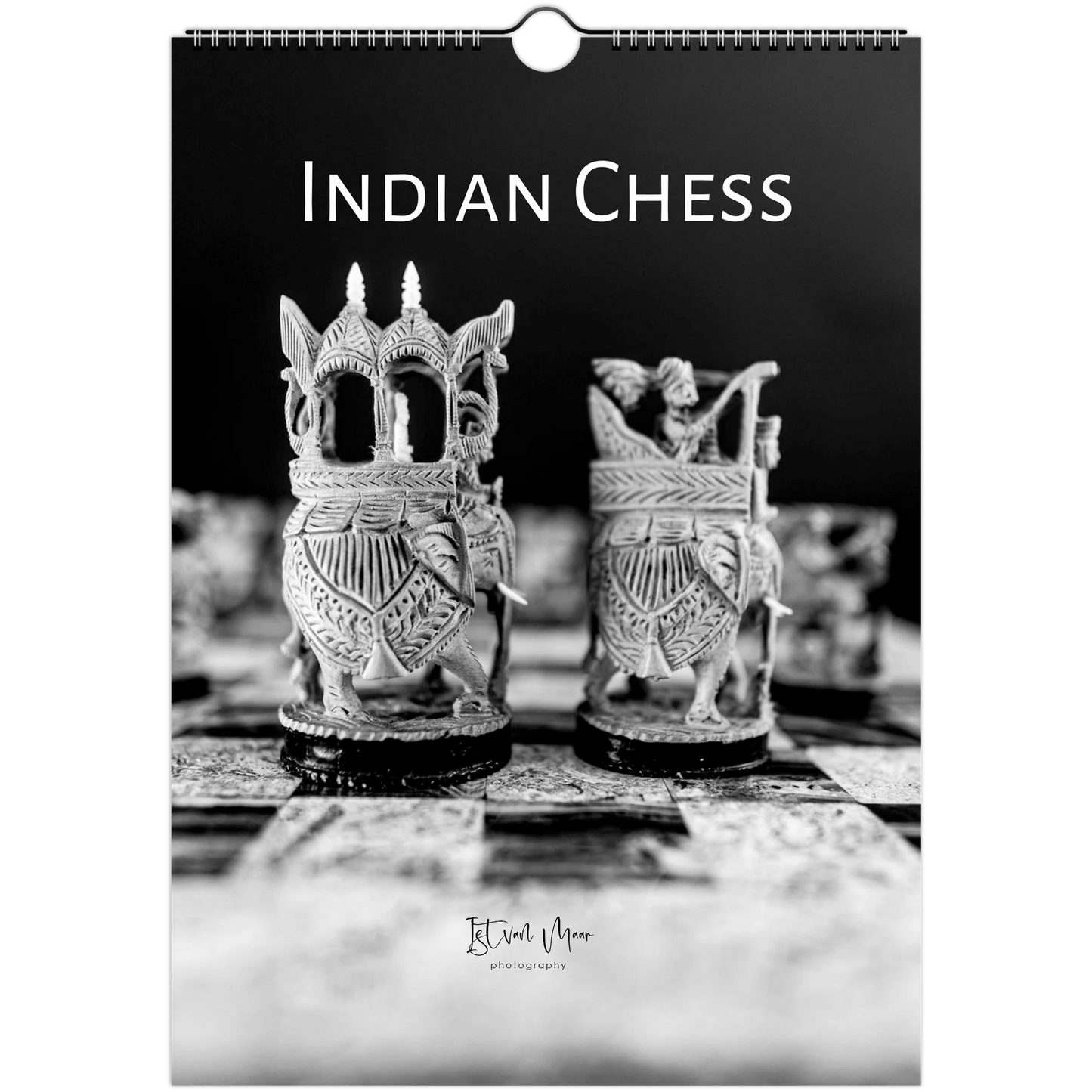 A spiral-bound wall calendar or print featuring a black-and-white photograph of ornate Indian chess pieces on a dark background, with the title 'INDIAN CHESS' at the top and a small photographer signature near the bottom.