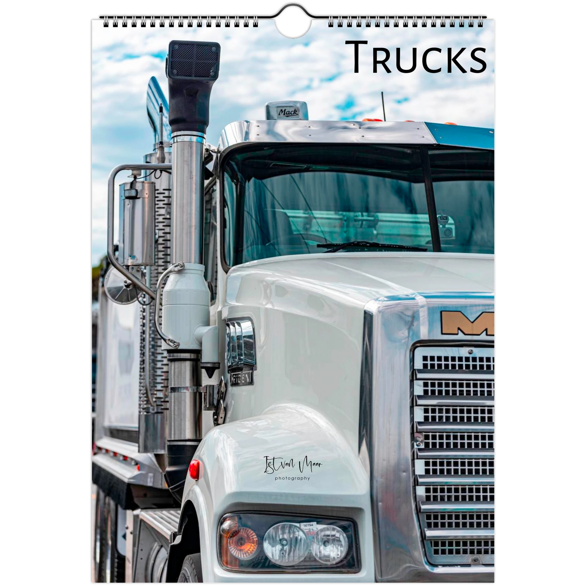 A spiral-bound wall calendar page featuring a close-up photograph of a white semi-truck with the word 'TRUCKS' printed at the top right.
