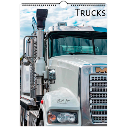 A spiral-bound wall calendar page featuring a close-up photograph of a white semi-truck with the word 'TRUCKS' printed at the top right.