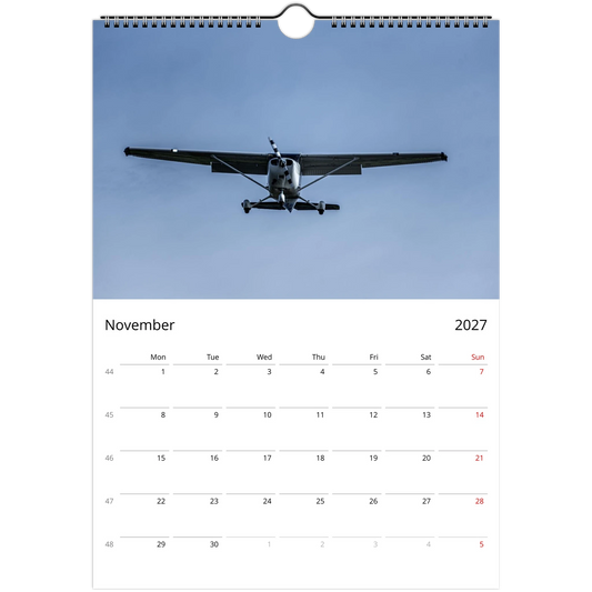 Calendar page for November 2027 with an airplane flying in the sky.