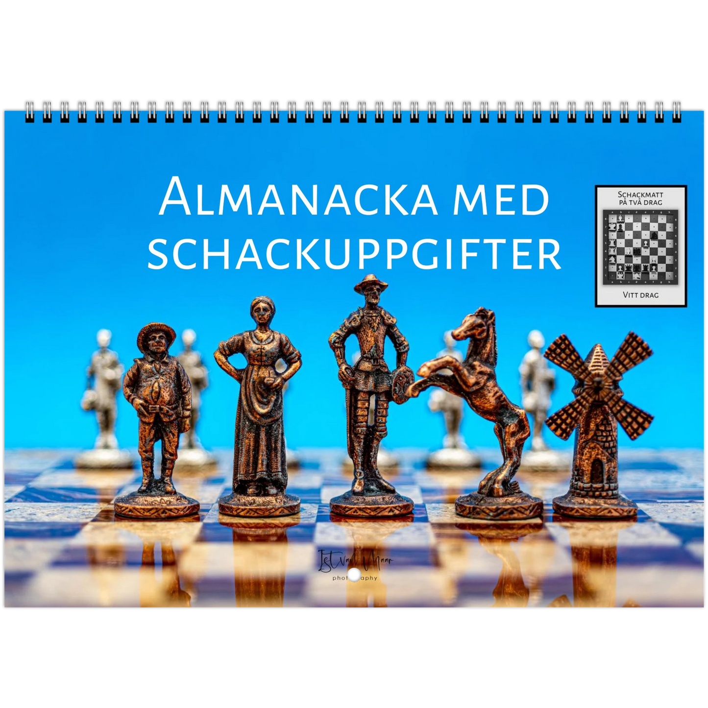 A spiral-bound book or album cover featuring a chessboard scene with bronze-colored chess pieces in the foreground and a bright blue background. Large white text reads 'ALMANACKA MED SCHACKUPPGIFTER,' and a small inset shows a chess puzzle. 