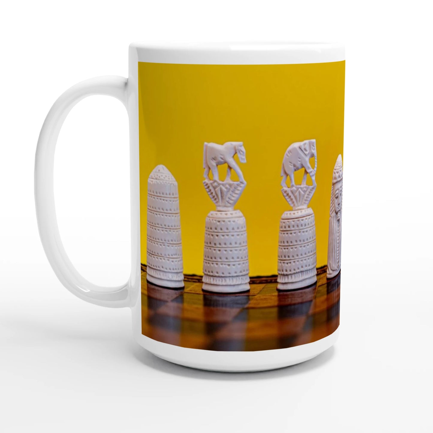 A white ceramic mug featuring a wrap-around graphic print of white decorative chess pieces on a dark wooden surface against a solid yellow background.