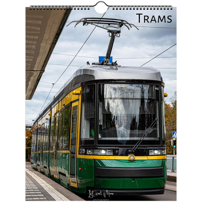 A spiral-bound wall calendar page featuring a photograph of a green and yellow tram at a station, with the word 'TRAMS' printed at the top and a small signature at the bottom.