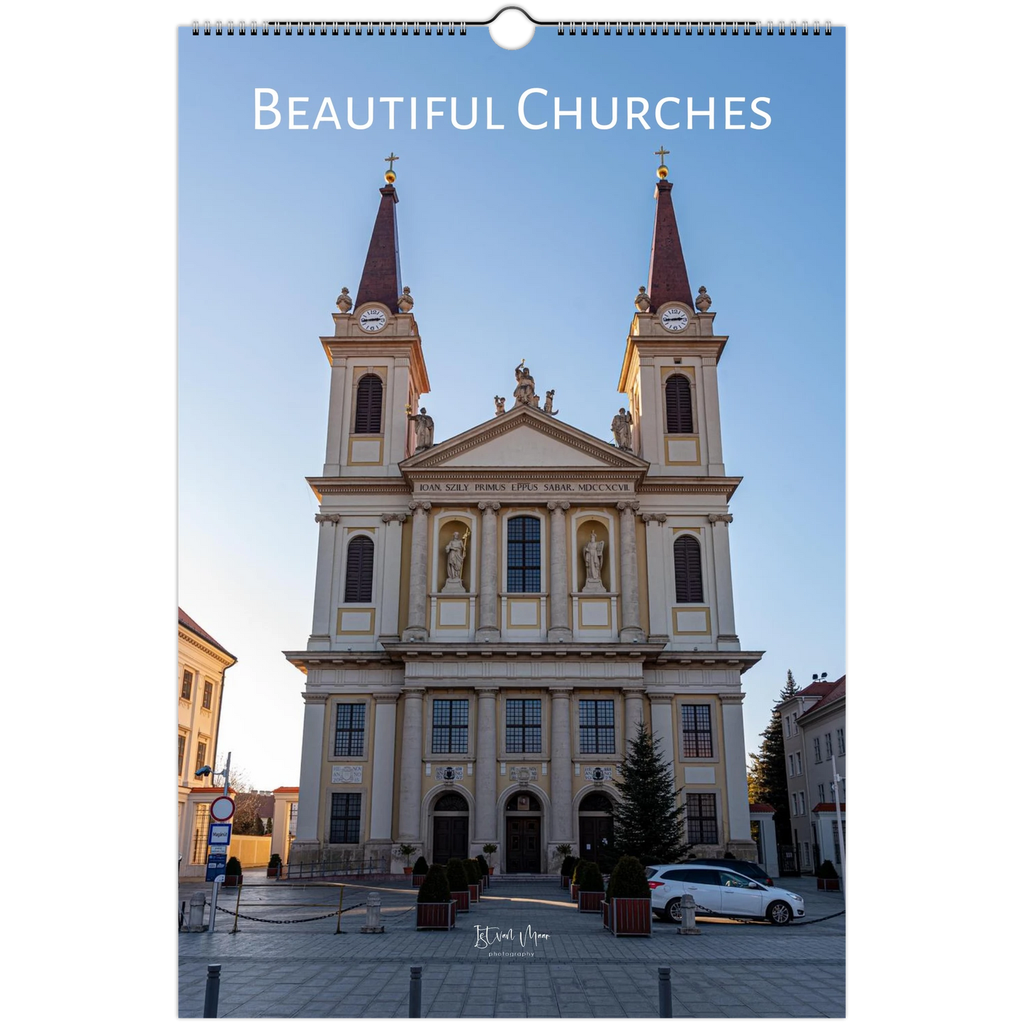 A spiral-bound wall calendar or print featuring a large photograph of a classical church facade with two towers, under the title 'Beautiful Churches' at the top. The scene is shown centered on a white background.