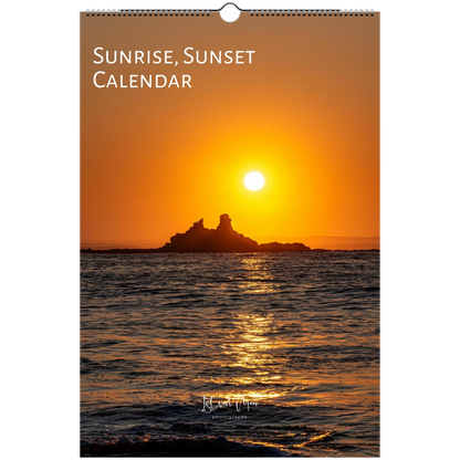 A wall calendar titled 'Sunrise, Sunset Calendar' featuring a scenic photograph of a bright sun over the ocean with a dark rocky island silhouette and golden reflections on the water.