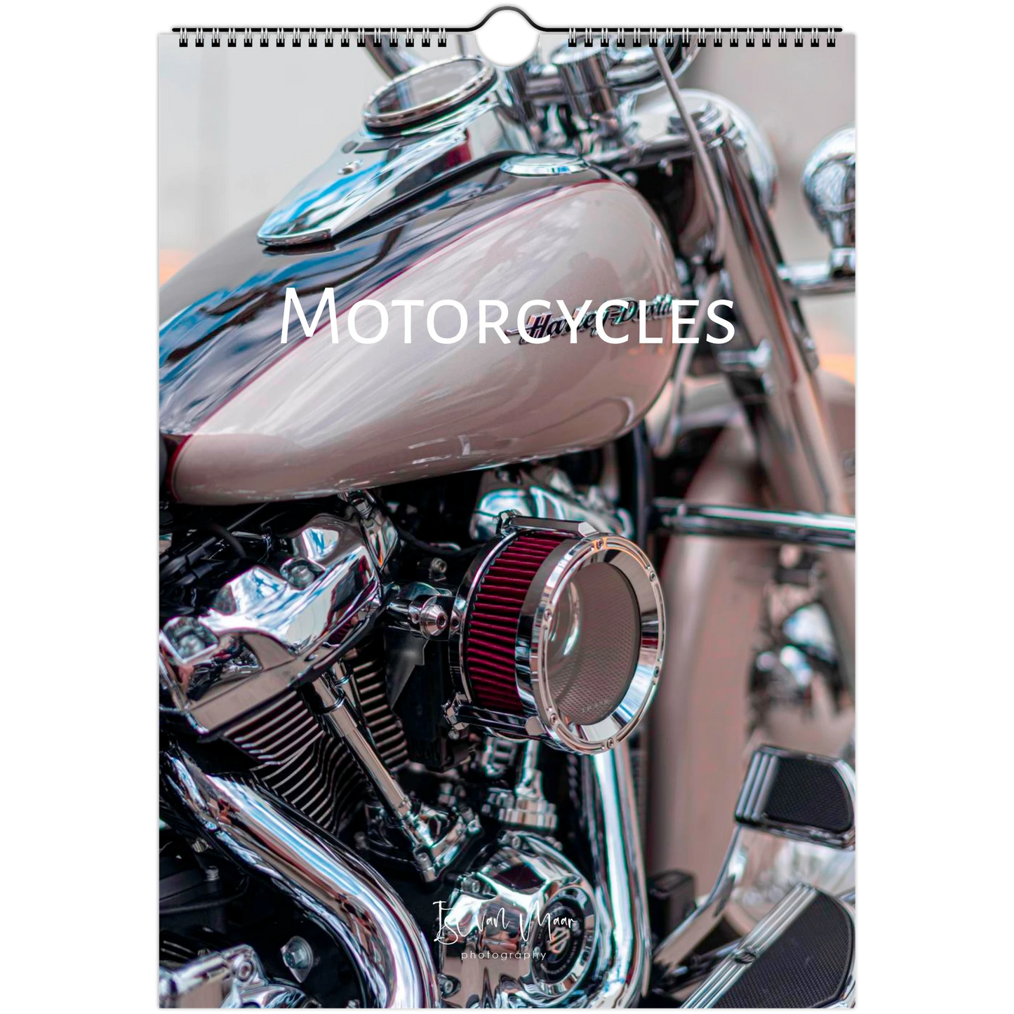 A wall calendar page featuring a close-up photograph of a motorcycle, with the word 'MOTORCYCLES' printed across the center. The calendar has a white border and a hanging tab at the top.